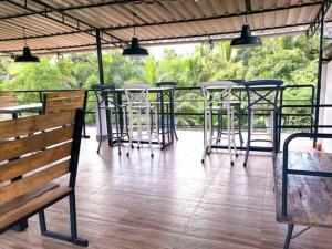 un patio avec des chaises, des tables et un banc dans l'établissement Cerca Del Mar, à Calangute