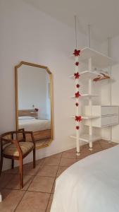 sypialnia z lustrem, krzesłem i łóżkiem w obiekcie Appartamento San Giorgio w mieście Lovere