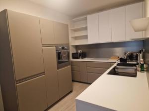 a kitchen with white cabinets and stainless steel appliances at Elegant Urban Residence with parking spot in Nivy