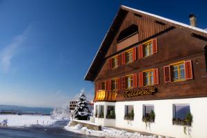 a building in the snow next to a street at Wellenhof Bodensee in Lochau