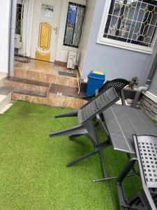 a patio with a table and chairs on the grass at Primier Mansion Guest Home in Limbe
