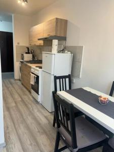 a kitchen with a white refrigerator and a table with chairs at Studio apartman Stefi in Samobor
