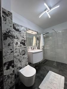 La salle de bains est pourvue de toilettes, d'un lavabo et d'une douche. dans l'établissement Charm Apartment, à Floreşti