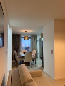 - un salon avec un canapé et une table à manger dans l'établissement Apartamento à 390m do Mar, à Itapema