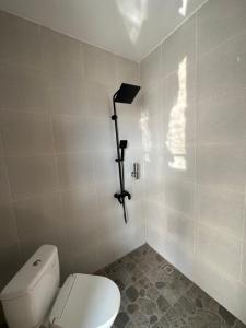 uma casa de banho com WC e uma câmara na parede em Pinggan Cliff em Baturaja