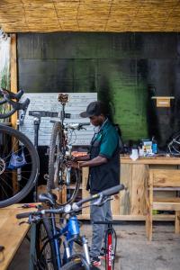 a man working on a bike in a workshop at Tugende Hostel in Kigali