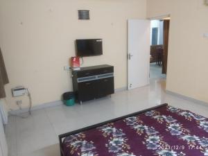 a bedroom with a bed and a flat screen tv at Royale Seaward Service Apartments in Chennai