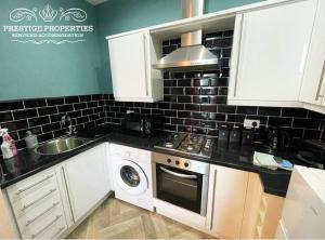 a kitchen with a sink and a stove top oven at Apartment 1 West County by Prestige Properties SA in Millom