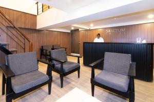 a man standing in a waiting room with chairs at Sanctum Suites Richmond Road Bangalore in Bangalore