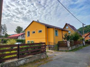 una casa amarilla con una valla delante de ella en Freya´s room, en Česká Kamenice