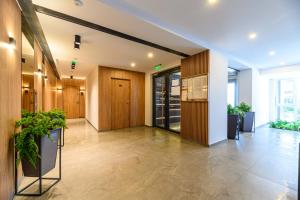 an office lobby with wooden doors and potted plants at Lara's Home in Braşov