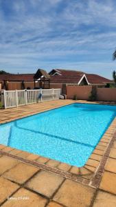 a large blue swimming pool in front of a house at Aloe Self Catering in Port Shepstone