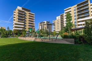 a playground in a park with two tall buildings at Lara's Home in Braşov