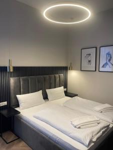 een slaapkamer met een groot bed met witte lakens bij Motel Blue Messe in Berlijn