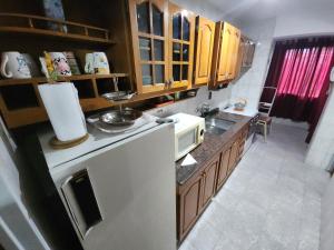 eine Küche mit Holzschränken und einem weißen Kühlschrank in der Unterkunft Departamento El Parral Parque Central in La Cieneguita