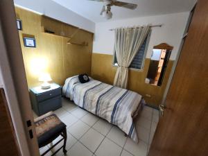 ein kleines Schlafzimmer mit einem Bett und einem Fenster in der Unterkunft Departamento El Parral Parque Central in La Cieneguita