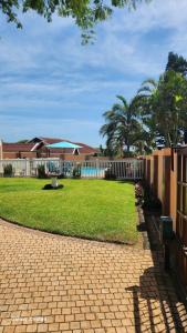 a backyard with a fence and a grass yard at Aloe Self Catering in Port Shepstone