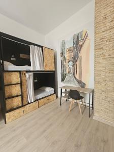 Zimmer mit einem Schreibtisch und Etagenbetten in der Unterkunft Planeta Cadiz Hostel in Cádiz