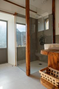 a bathroom with a tub and a shower with a window at La tête dans les nuages et les pieds dans l'eau in Saint-Benoît-en-Diois