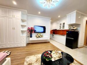 uma cozinha com armários brancos e uma mesa preta em Homestay HaLong studio em Ha Long