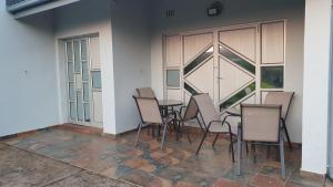 a group of chairs and a table in front of a building at Mesda Bed & Breakfast in Empangeni