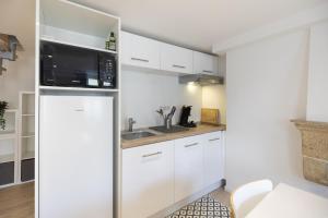 małą kuchnię z białymi szafkami i lodówką w obiekcie Ville de Coeur w mieście Thionville