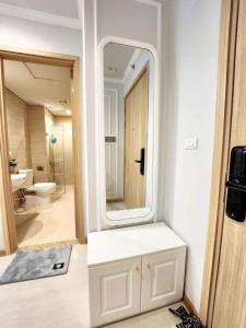 uma casa de banho com um espelho e um armário branco em Homestay HaLong studio em Ha Long