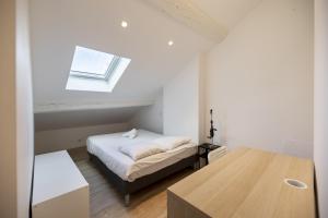 mała sypialnia z łóżkiem i oknem w obiekcie Ville de Coeur w mieście Thionville