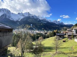 a village in the mountains with snow capped mountains at Appartamenti dolomitici in Padola