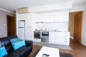 a living room with a couch and a kitchen at Lovely 2BR Apartment in West Perth with Parking! in Perth