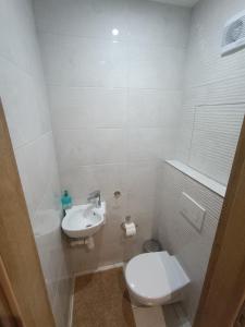 ein weißes Bad mit einem WC und einem Waschbecken in der Unterkunft Apartmán Lúčky Bojnice in Bojnice