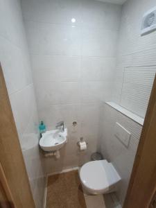 a white bathroom with a toilet and a sink at Apartmán Lúčky Bojnice in Bojnice +14 photos