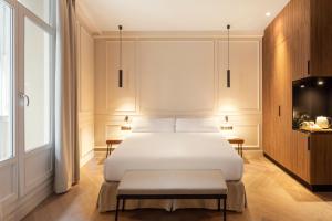 a bedroom with a white bed and a tv at Bilder Boutique Hotel in Bilbao