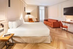 a hotel room with a large bed and a couch at Bilder Boutique Hotel in Bilbao