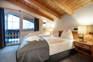 a bedroom with a large white bed and a window at BERGZEIT by seven in Flachau