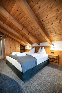 ein großes Bett in einem Zimmer mit Holzdecken in der Unterkunft BERGZEIT by seven in Flachau