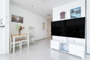 Nasma Luxury Stays - Serenity by the Sea 1BR Apartment With Beach Views في أبوظبي: غرفة معيشة مع تلفزيون بشاشة مسطحة كبيرة