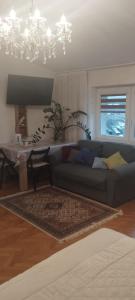 uma sala de estar com um sofá e um lustre em A cosy private room in the heart of old Podgorze em Cracóvia