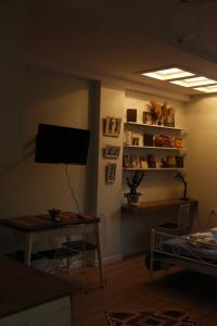 uma sala de estar com uma mesa e uma televisão em Illyrian studio apartment 2 em Tirana