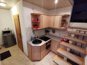 una pequeña cocina con armarios de madera y fregadero en Schnorr-Villa, en Schneeberg