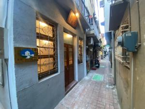 a narrow alley with a person sitting outside of a building at 寛宅 1960 包棟民宿 in Tainan