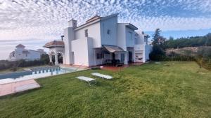 a large white house with a lawn and a pool at villa star hill Tanger in Tangier