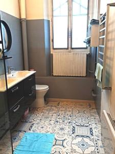 a bathroom with a sink and a toilet and a window at appartement dans une meulière d'architecte in Provins