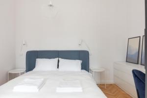 een slaapkamer met een bed met een blauw hoofdeinde bij Designer Apartment in the Central Warsaw in Warschau