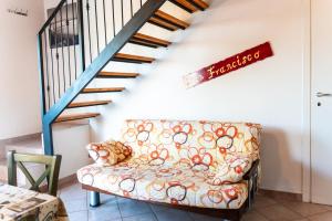 a living room with a couch and a staircase at Residence IL Villaggio del Re in Corropoli