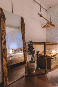 uno specchio in una stanza con un letto e una pianta di Nomadic villa a Mukteshwar
