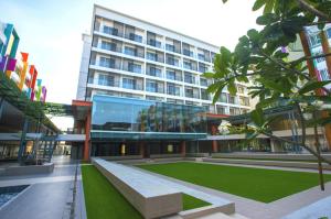 M Suite Homestay, Aeropod Sovo Kota Kinabalu في Tanjong Aru: مبنى كبير مع حديقة أمامه