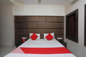 una camera da letto con un grande letto con cuscini rossi di Hotel South Fern a Ballygunge