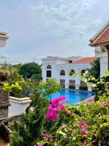 a view of a building with a swimming pool and flowers at Hoa Nam Hotel 