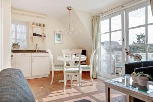 eine Küche und ein Esszimmer mit Tisch und Stühlen in der Unterkunft Friesenhörn, App. 4 links in Wenningstedt-Braderup